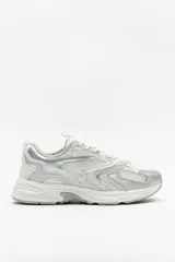 Zapatillas urbanas blancas con detalles plateados, confeccionadas en malla y material sintético.