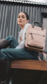 Mochila combinada en tres tonos de símil cuero, con doble bolsillo frontal, asa de mano y correas regulables.