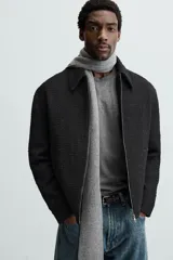 Sobrecamisa de hombre regular fit confeccionada en tejido con estructura irregular en tonos beige, marrón y negro. Tiene cuello solapa, manga larga con puños abotonados, bolsillos laterales y cierre frontal con cremallera.