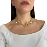 Collar dorado de cadena gruesa con dijes colgantes de acero y nácar blanco: perla, corazón, flor, trébol y círculo con logo.