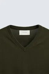 Jersey verde oscuro de punto fino, con cuello en V y mangas largas.