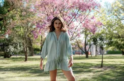 Vestido corto blanco con escote en V, mangas 3/4 con detalle de calado y volados en el ruedo. Cierre frontal con botones.