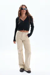 Saco de tejido punto negro con hilo de Lurex, escote en V y cierre frontal con botones. Presenta aberturas en los puños de las mangas largas.