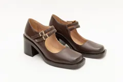 Guillermina de cuero negro con punta cuadrada, taco bloque y correa sobre el empeine con hebilla dorada.