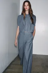 Pantalón de tiro alto con trabillas, bolsillos laterales y de parche en la espalda. Cierre frontal con cremallera y ganchos metálicos.