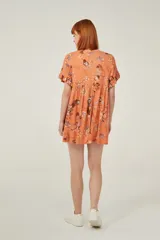 Vestido corto color naranja con estampado floral multicolor, de corte holgado y mangas cortas con volados.