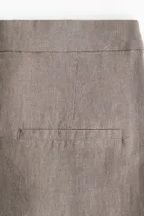 Pantalón de vestir color gris topo, de tiro alto, corte amplio y largo hasta el tobillo. Confeccionado en tejido liviano de mezcla de lino y viscosa.
