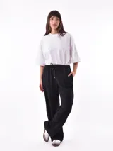 Pantalón de jogging negro con cintura elástica ajustable con cordón, bolsillos laterales y detalle de encaje en los laterales.
