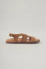 Sandalias planas de cuero color marrón claro, con múltiples tiras cruzadas y hebilla lateral.