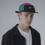 Gorra de cinco paneles con visera plana, color negro con secciones en verde y fucsia.