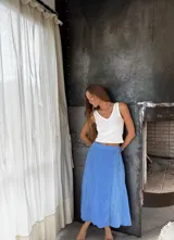 Pollera midi tipo pareo de lino color celeste. Tiene elástico en la parte trasera de la cintura y se ata con lazo en la parte delantera.