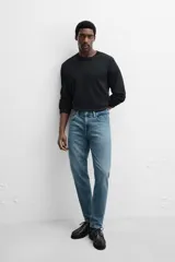 Pantalón de jean azul oscuro, corte slim fit, tiro medio, cinco bolsillos, tejido elástico y efecto lavado.