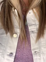 Campera de jean oversize, color rojo desgastado, con aplicaciones de tapicería multicolor de estilo étnico en hombros y ruedo, y terminaciones desflecadas.