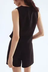 Short pollera mini de viscosa color negro. Diseño cruzado con botón y cierre lateral oculto.