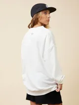 Sweater blanco con estampado de sol, olas y texto en rosa y verde.