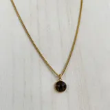 Collar de acero dorado con dije de piedra natural color marrón, diseño elegante y delicado.