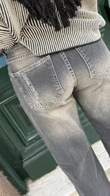 Pantalón de jean gris oscuro, de corte recto y tiro medio, con costuras decorativas en contraste.