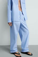 Pantalón de pijama celeste de algodón, corte relaxed fit, con cintura elástica ajustable con cordón interior, bolsillos laterales y detalle de vivos combinados a contraste en el bajo.