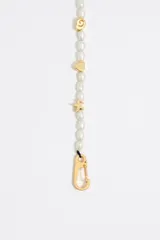 Pulsera de perlas cultivadas con dijes dorados de motivos marinos y cierre de mosquetón dorado.