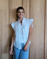 Chaleco blanco de broderie con cuello mao, sin mangas y cierre frontal con botones.