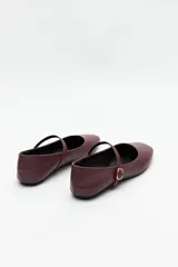 Balerinas color borgoña de cuero sintético texturizado, con tira sobre el empeine y hebilla metálica ajustable.