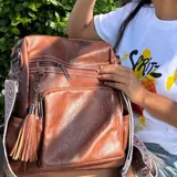 Mochila marrón de eco-cuero con monedero de regalo. Tiene capacidad para una laptop de 15.6 pulgadas.