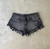 Short de jean negro con lavado gastado y terminaciones desflecadas.
