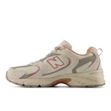 Championes urbanos New Balance modelo 530, color crema con detalles en beige y naranja, confeccionados en malla y cuero sintético, con logo "N" característico en los laterales y entresuela ABZORB.