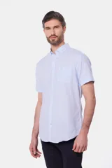 Camisa celeste de lino y algodón, de manga corta, con cuello abotonado y bolsillo en el pecho.
