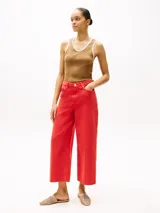Pantalón jean de pierna ancha color rojo, de talle alto y corte tobillero.