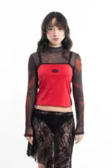 Top deportivo rojo con breteles finos y ribete negro, con logo ovalado en el pecho y dos líneas verticales negras en los laterales.