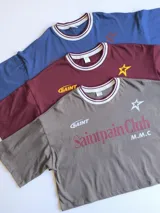 Remera azul con estampado frontal con el texto "Saintpain Club" en blanco y una estrella roja.