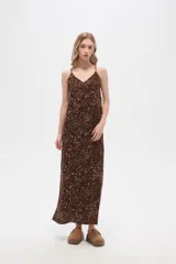 Vestido largo con estampado animal print en tonos beige y negro, breteles finos y corte holgado.
