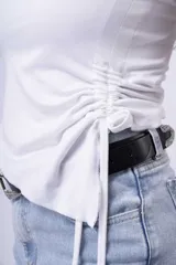 Strapless blanco con frunce lateral y tiras ajustables.