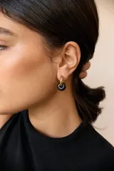 Aros de acero quirúrgico hipoalergénico con piedras naturales azules. Diseño de aro con dije circular colgante.