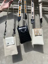 Cartera pequeña tipo phone bag, con correa larga de tela con letras.