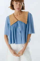 Camisa celeste de corte holgado con cuello babero color camel con estampado floral.