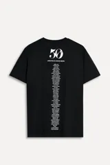 Camiseta blanca de algodón con cuello redondo y mangas cortas. Estampado fotográfico en blanco y negro con un grupo de personas y texto "Steven Meisel NYC February 12, 2025".