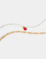 Collar corto de doble cadena, una de perlas y otra dorada con dijes de frutillas. Incluye un dije de vaquita de San Antonio.