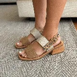 Sandalias de cuero color tostado con dos tiras, una de cuero liso y otra con estampado animal print.