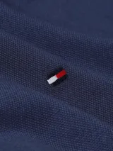 Camisa Tommy Hilfiger de corte slim fit, color azul marino, confeccionada en tejido dobby de algodón con tecnología Flex. Tiene cuello abotonado, manga larga y logo bordado en el pecho.