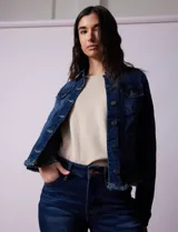 Campera de jean azul de la marca Baccini, con cuello solapa, abertura central con botones metálicos, bolsillos delanteros y ruedo desflecado.