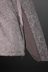 Cazadora con capucha confeccionada en tejido técnico ligero con partículas reflectantes. Cuenta con cuello alto, mangas largas con puños elásticos, bolsillos frontales con cierre de cremallera y cierre frontal con cremallera.