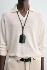 Sweater color crema de punto, con cuello polo y mangas largas. Tejido en hilatura de cáñamo con acabados en rib.