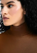 Polera negra de cuello alto, manga larga y tejido acanalado.