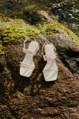 Sandalia de tiras color crudo con taco medio.