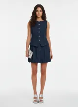 Minifalda de jean azul oscuro, de tiro medio, corte globo y textura rígida.