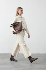 Pantalón de denim azul oscuro con corte flare, ajustado en la cadera y amplio en el ruedo. Presenta pespuntes a contratono en color blanco que resaltan las costuras.