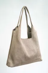 Bolso negro tipo tote bag con textura acanalada y asas de hombro.