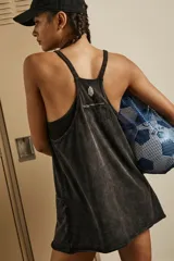 Vestido deportivo corto color blanco, con escote redondo, tirantes finos y espalda cruzada. Incluye bolsillos de parche grandes en el frente y forro interior con costuras para shorts incorporados.